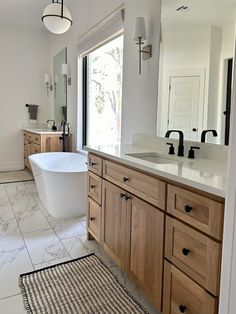 a bath room with a tub a sink and a rug on the floor in front of a window