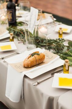 a table set up for a wedding with place settings and napkins on the table