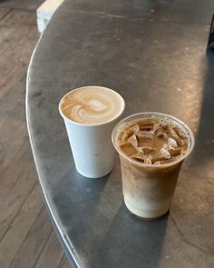 two cups of coffee sitting on top of a table