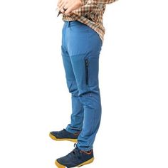 a man standing with his hands on his hips wearing blue pants and a plaid shirt