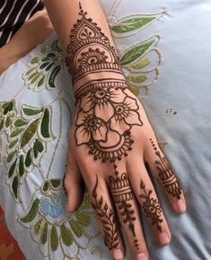 a woman's hand with henna tattoos on it