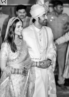 the bride and groom are standing together in black and white, smiling at each other