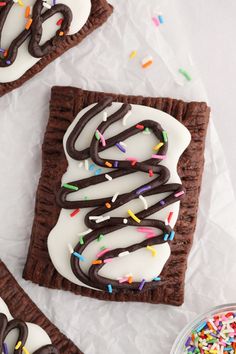 chocolate and sprinkles are on top of a cookie crust with white frosting