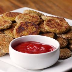 there are some fried food on the plate with ketchup in a bowl next to it