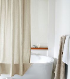 a white bath tub sitting next to a shower curtain