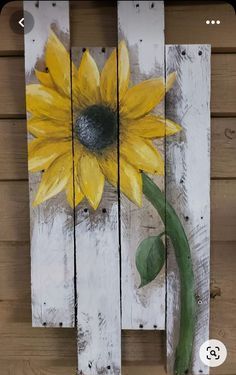 a painted sunflower on a white wooden planks