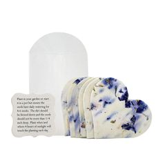 four soaps with blue and white designs next to a bottle of liquid on a white background