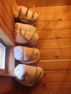 towels are lined up in the corner of a cabin with deer antlers on them