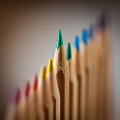 a row of colored pencils sitting on top of each other