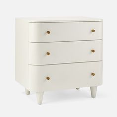 a white dresser with three drawers and gold knobs