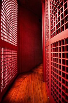 an empty room with red walls and wooden floors