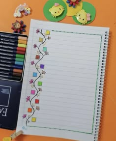 an open notebook sitting on top of a table next to crayons