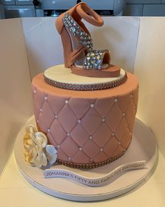 a pink cake with high heel shoes on top