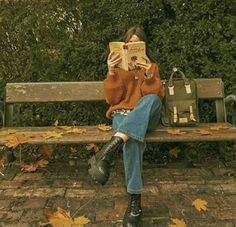 a woman sitting on a bench reading a book