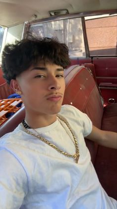 a young man sitting in the back seat of a car with donuts behind him