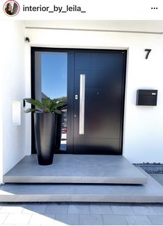 a large black planter sitting in front of a door