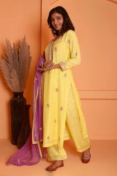 Yellow kurta featuring dori embroidered floral and paisley motifs highlighted with gota lace embellishments. Comes with palazzo and dupatta.
Components: 3
Pattern: Embroidered
Type Of Work: Floral, Gota, Dori
Neckline: Round
Sleeve Type: Three quarter
Fabric: Cotton Silk
Color: Yellow
Other Details: 
Length:
Kurta: 47 Inches
Palazzo: 38 Inches
Dupatta: 2.5 Mtr 
Occasion: Sangeet,Mehendi and Haldi - Aza Fashions Fitted Dola Silk Palazzo Set With Chikankari Embroidery, Embroidered Fitted Palazzo Set In Dola Silk, Semi-stitched Slub Silk Salwar Kameez With Floral Embroidery, Bollywood Embroidered Slub Silk Sets, Bollywood Style Embroidered Slub Silk Sets, Fitted Multicolor Palazzo Set With Zari Work, Semi-stitched Art Silk Palazzo Set With Chikankari Embroidery, Art Silk Palazzo Set With Chikankari Embroidery, Tissue Silk Unstitched Suit With Dabka Work