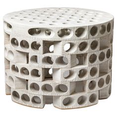 a white stool with holes in it on a white background and the bottom section is made out of concrete blocks