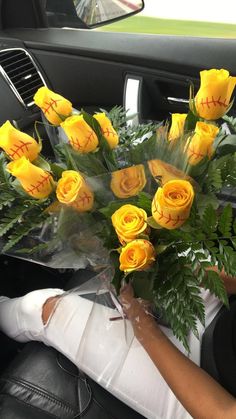 a bouquet of yellow roses sitting in the passenger seat of a car