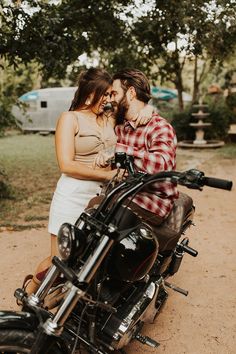 a man and woman are sitting on a motorcycle