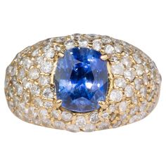 a blue and white diamond ring with two rows of diamonds around the band, set in 18k yellow gold