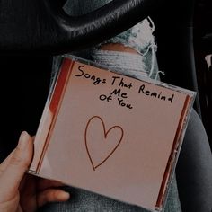 someone holding up a cd with a heart drawn on it and the words songs that remind me are out