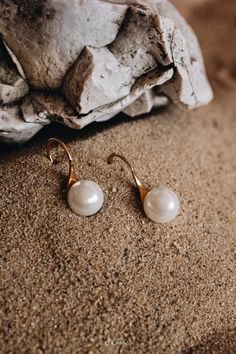 Elevate your elegance with our Natural Freshwater Pearl Hook Earrings. These minimalist pearl drops, crafted for refined taste, are perfect as huggie earrings. A timeless gift for Mom or a sophisticated bridesmaid gesture. Experience the luxury and delicacy only Liora offers. HIGHLIGHTS Basis: Solid 925 Sterling Silver Plating: 18K Gold Vermeil Earrings Gem: High Quality Freshwater White Pearl SIZE Pearl: 10 mm (0.39 in) Full length: 25 mm (0.98 in) FEATURES Hypoallergenic Nickel-free Waterproof Elegant Pearl Drop Shell Earrings, Gold Pearl Drop Earrings With Shell, Shell-shaped Pearl Drop Earrings For Gifts, Gold Shell-shaped Pearl Earrings, Gold Pearl Shell-shaped Earrings, Timeless Gifts, Earrings Minimalist, Huggie Earrings, Pearl Size