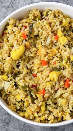 a white bowl filled with rice and vegetables on top of a gray countertop next to a green sign that says jamaican seasoned rice