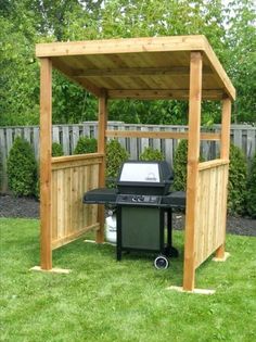 an outdoor bbq with grill in the middle of it and grass area behind it