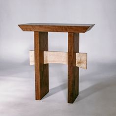 a small wooden table with one section cut out to look like a cross on it