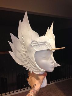 a person wearing a white mask with wings on it's head