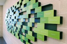 a green and black wall mounted on the side of a building