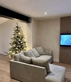 a living room with a christmas tree in the corner and a couch next to it