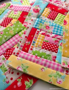 a colorful patchwork quilt on top of a table with flowers and polka dotes