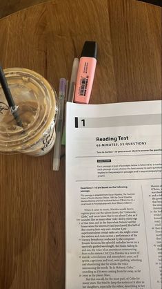 a table with some pens and paper on it next to a jar of markers, pencils and a pen