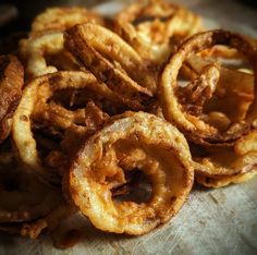 fried onion rings are piled on top of each other