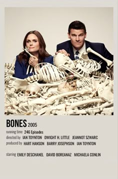 a man and woman sitting next to each other in front of a pile of bones