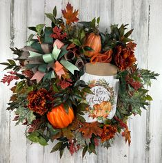 an autumn wreath with pumpkins and leaves on a white wooden background, surrounded by fall foliage