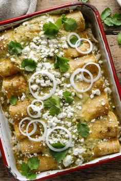 an enchilada dish with onions, cheese and cilantro