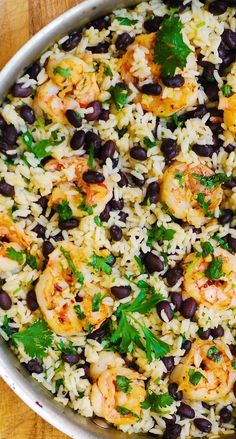 rice with shrimp and black beans in a pan on a wooden table, ready to be eaten