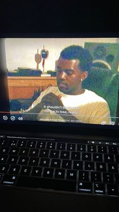 a laptop computer sitting on top of a desk with a screen showing a man's profile