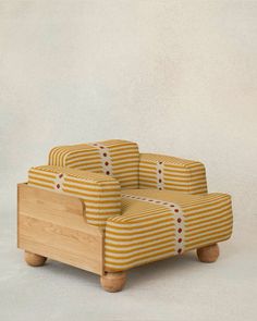 an upholstered wooden chair with yellow and white striped fabric on the back, in front of a plain background