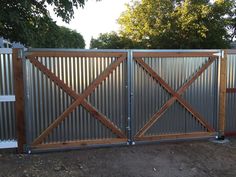 a metal fence with wooden gates on top of it