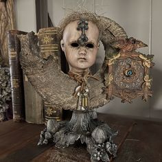 an antique clock with a creepy face on it's head and bookends in the background