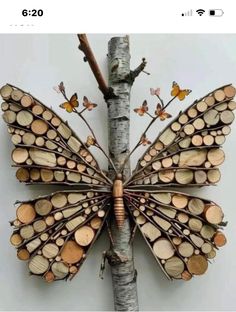 a butterfly made out of wood sitting on top of a tree