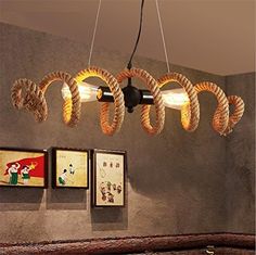 a light that is hanging from a ceiling in a room with pictures on the wall