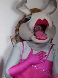 a woman in bunny costume with her mouth open and hands on her hips, standing next to a wall