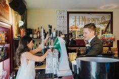 a bride and groom are at the bar