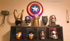 a shelf filled with assorted avengers masks on top of it