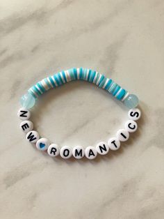 a blue and white beaded bracelet with the words new york on it, sitting on a marble surface